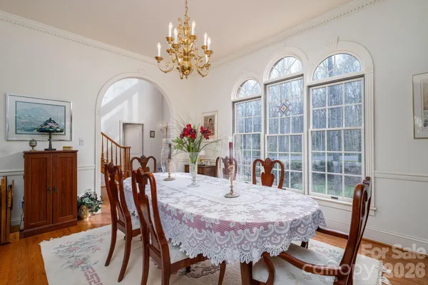 a dining room with furniture a chandelier and wooden floor