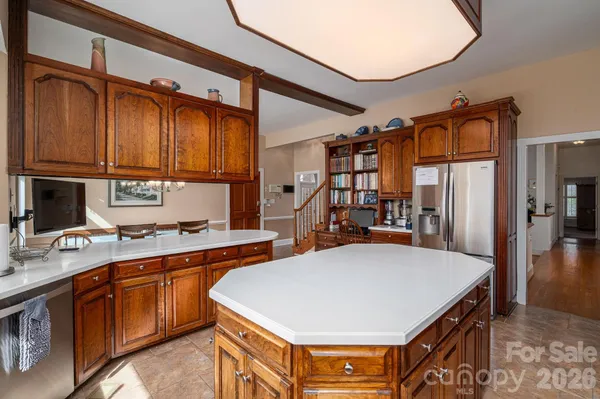 a kitchen with stainless steel appliances a stove a refrigerator a sink dishwasher and cabinets with wooden floor