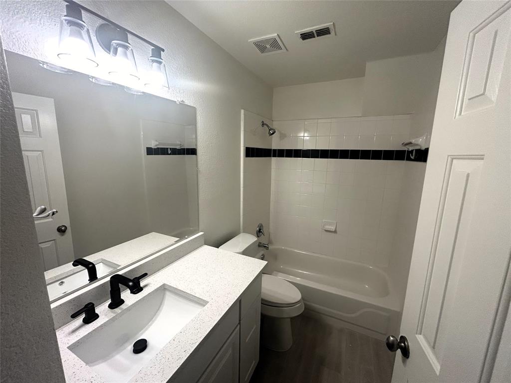3112 Mason Avenue Corinth, TX 76210 - Photo 14 of 21 a bathroom with a sink a toilet a mirror and shower