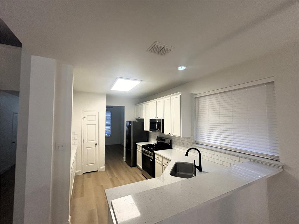 3112 Mason Avenue Corinth, TX 76210 - Photo 5 of 21 a kitchen with granite countertop a sink stainless steel appliances and cabinets