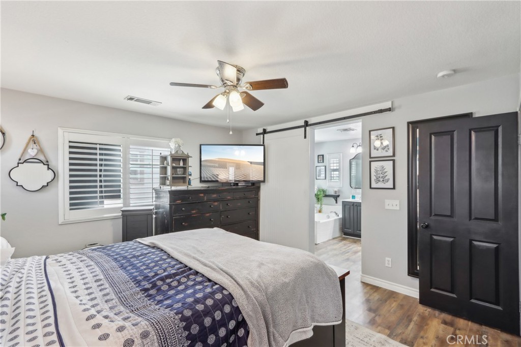 33971 Lily Road Yucaipa, CA 92399 - Photo 14 of 29 a bedroom with a large bed and a chandelier