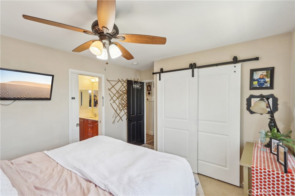 33971 Lily Road Yucaipa, CA 92399 - Photo 18 of 29 a bedroom with a bed and a chandelier