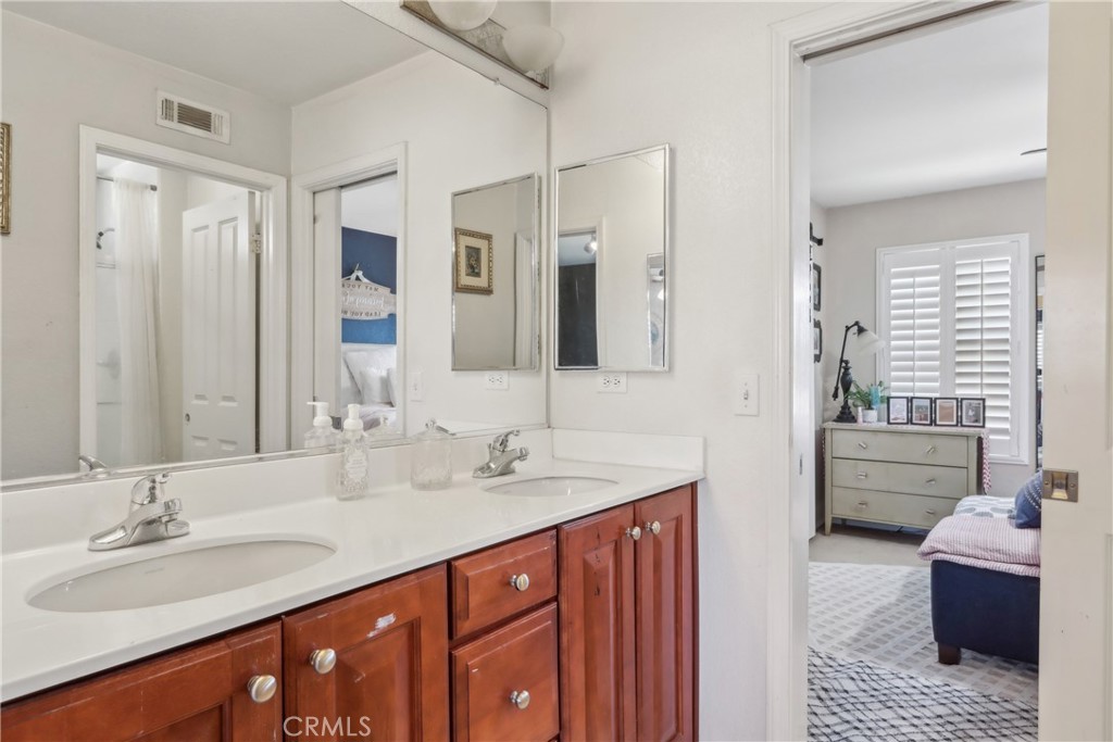 33971 Lily Road Yucaipa, CA 92399 - Photo 20 of 29 a bathroom with a double vanity sink a large mirror and a bathtub