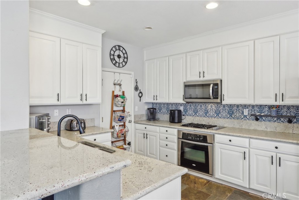 33971 Lily Road Yucaipa, CA 92399 - Photo 5 of 29 a kitchen with white cabinets and sink