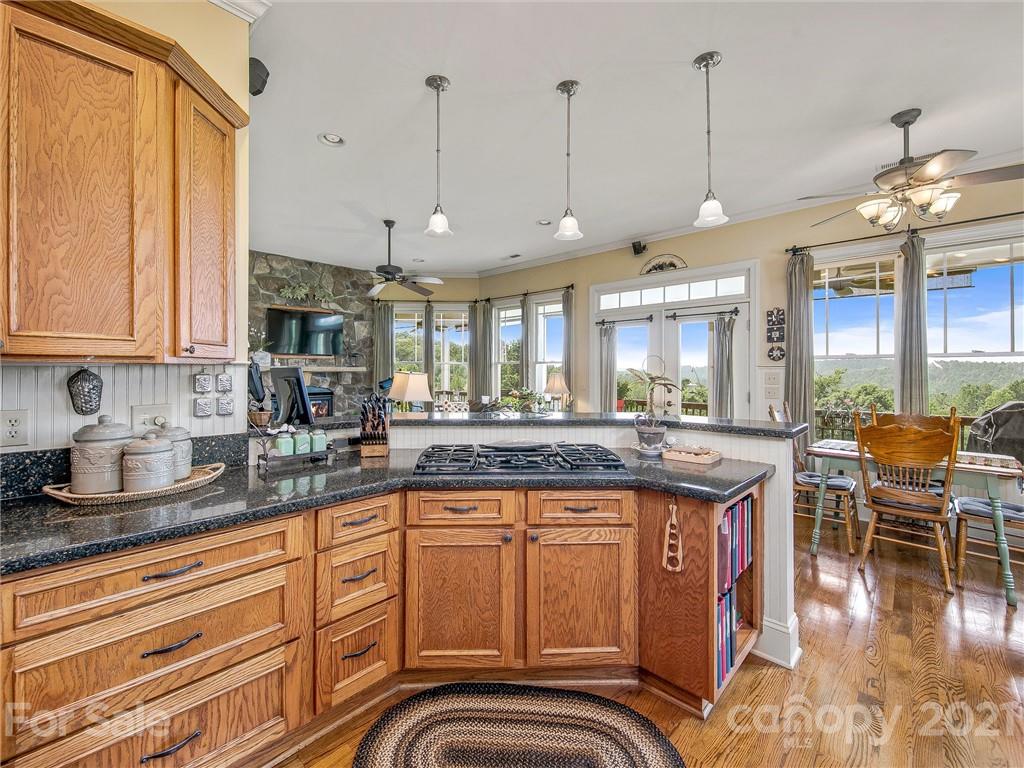 3043 John Watson Road Rutherfordton, NC 28139 - Photo 16 of 48 a kitchen with stainless steel appliances granite countertop a stove a sink dishwasher and white cabinets with wooden floor