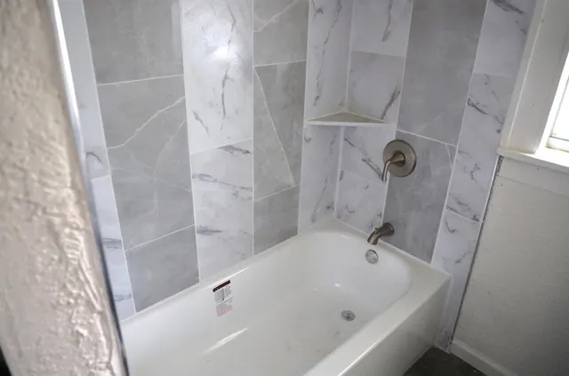 a bathroom with a tub and shower