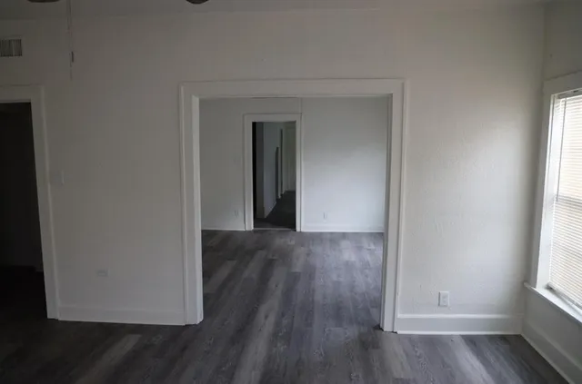 a view of a room with wooden floor and a window