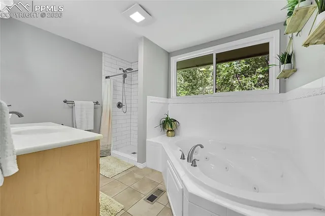a bathroom with a tub a sink and a window