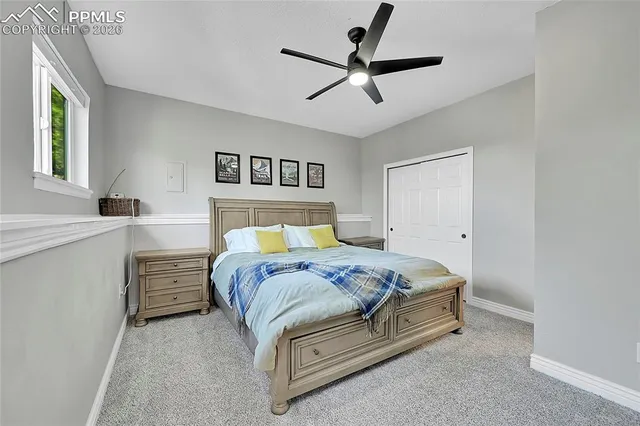a bedroom with a bed and a ceiling fan