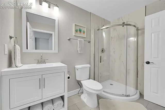 a bathroom with a granite countertop sink toilet a mirror a vanity and shower