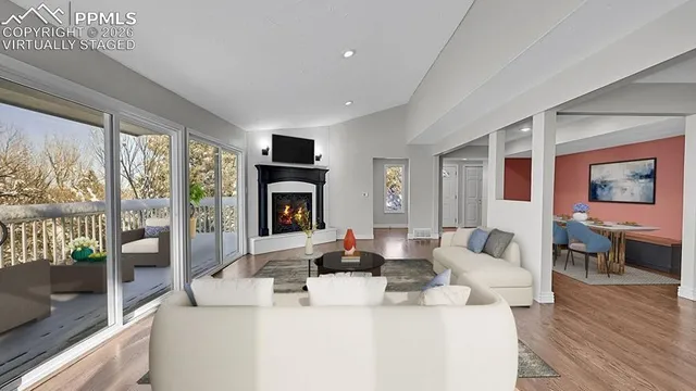 a living room with furniture large window and wooden floor