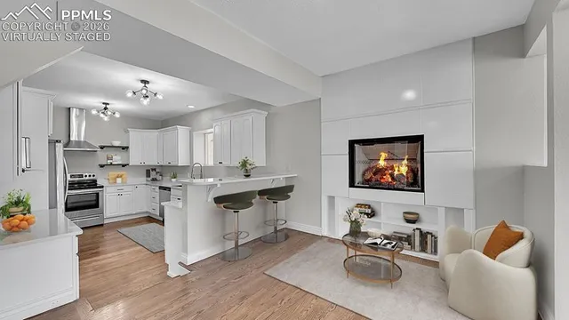 a living room with furniture kitchen view and a flat screen tv