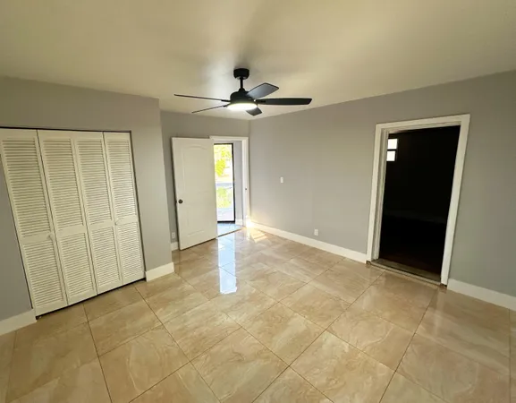 an empty room with fan and entrance