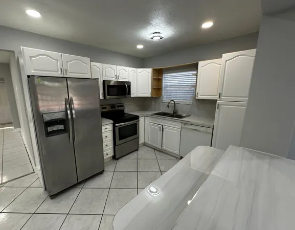 a kitchen with stainless steel appliances a refrigerator sink and microwave