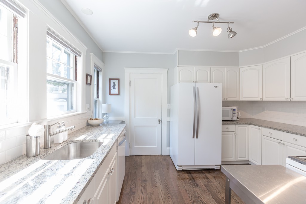 32 Skahan Road, Unit 32 Belmont, MA 02478 - Photo 9 of 18 a large kitchen with a refrigerator a sink and dishwasher with wooden floor