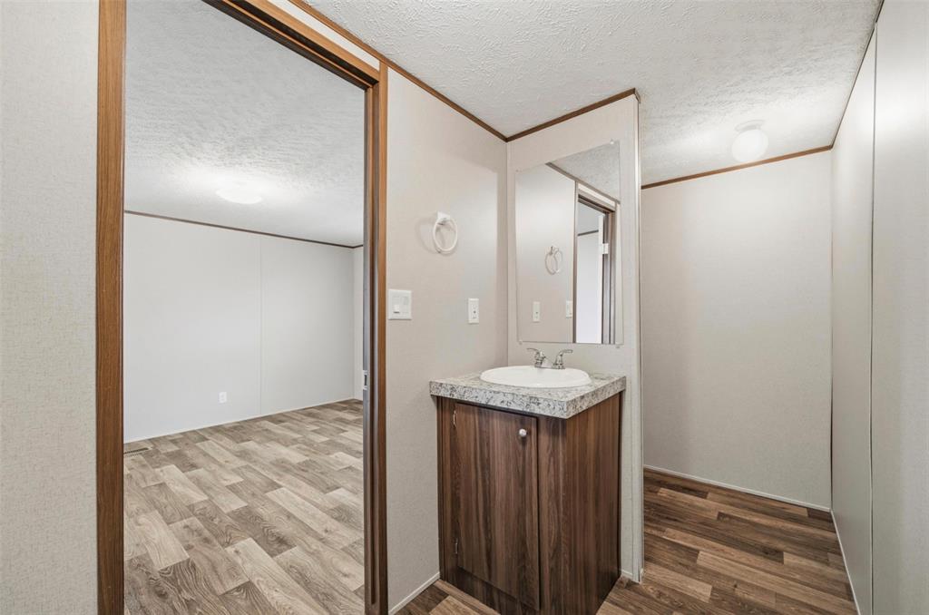 205 Park Street Frost, TX 76641 - Photo 11 of 19 a bathroom with a granite countertop sink and a mirror