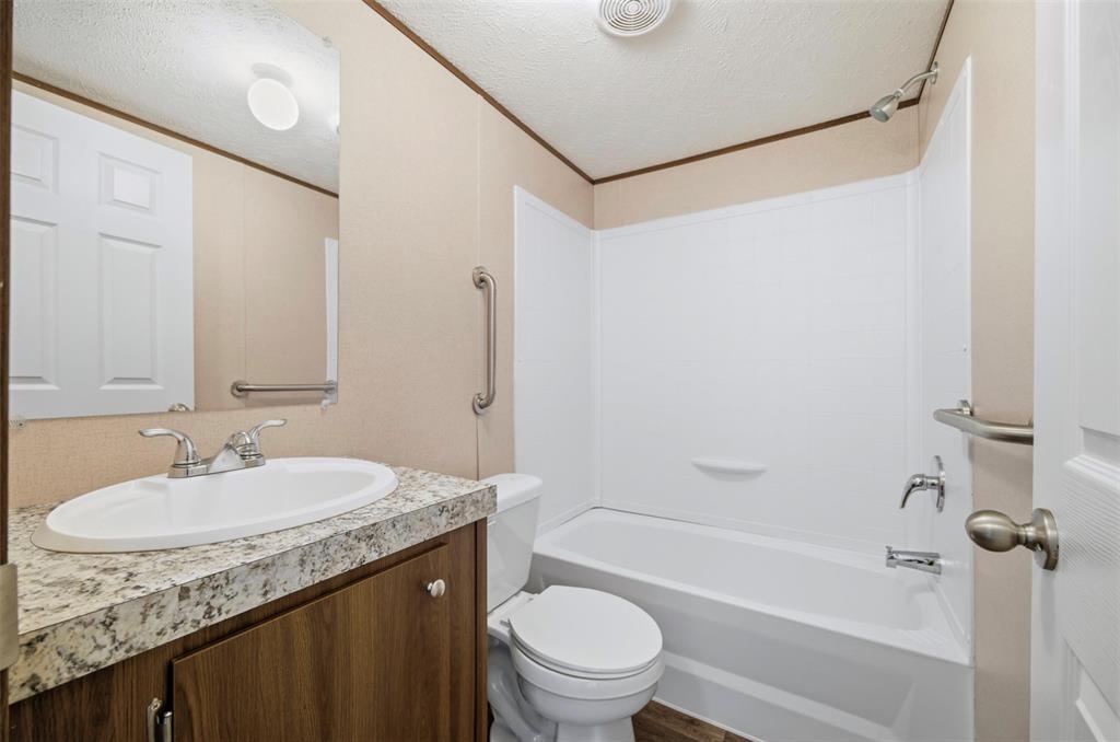 205 Park Street Frost, TX 76641 - Photo 12 of 19 a bathroom with a granite countertop sink toilet and shower