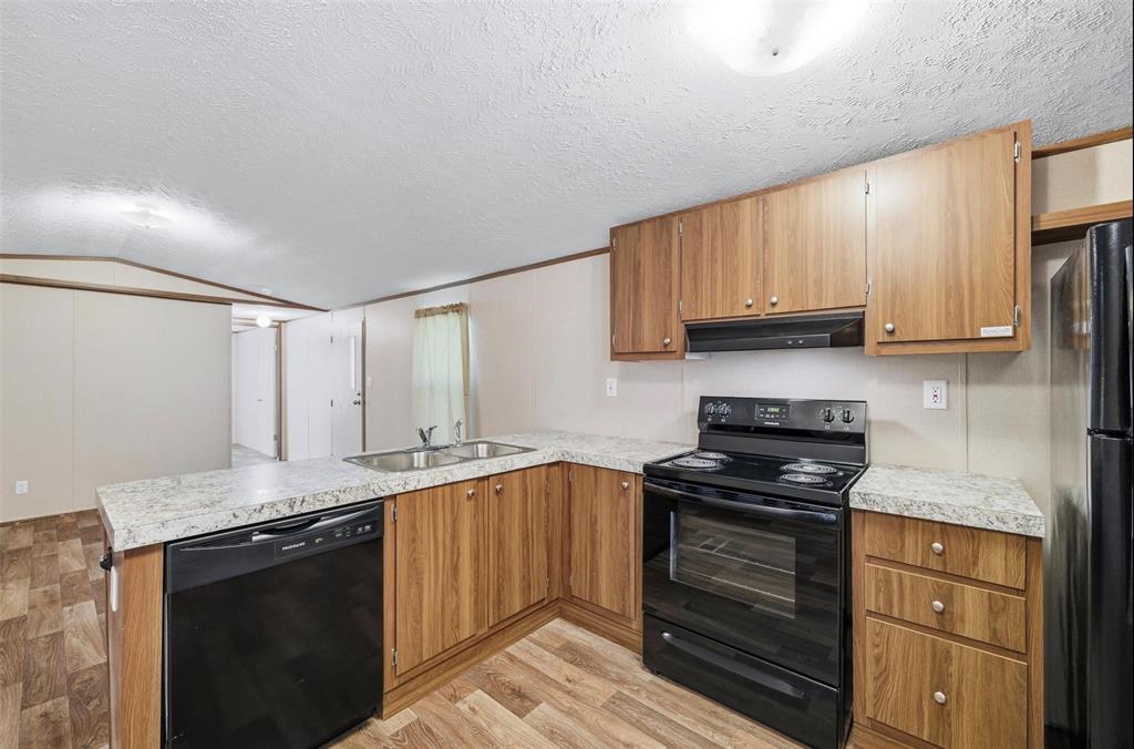 205 Park Street Frost, TX 76641 - Photo 5 of 19 a kitchen with stainless steel appliances granite countertop a stove a sink and a microwave