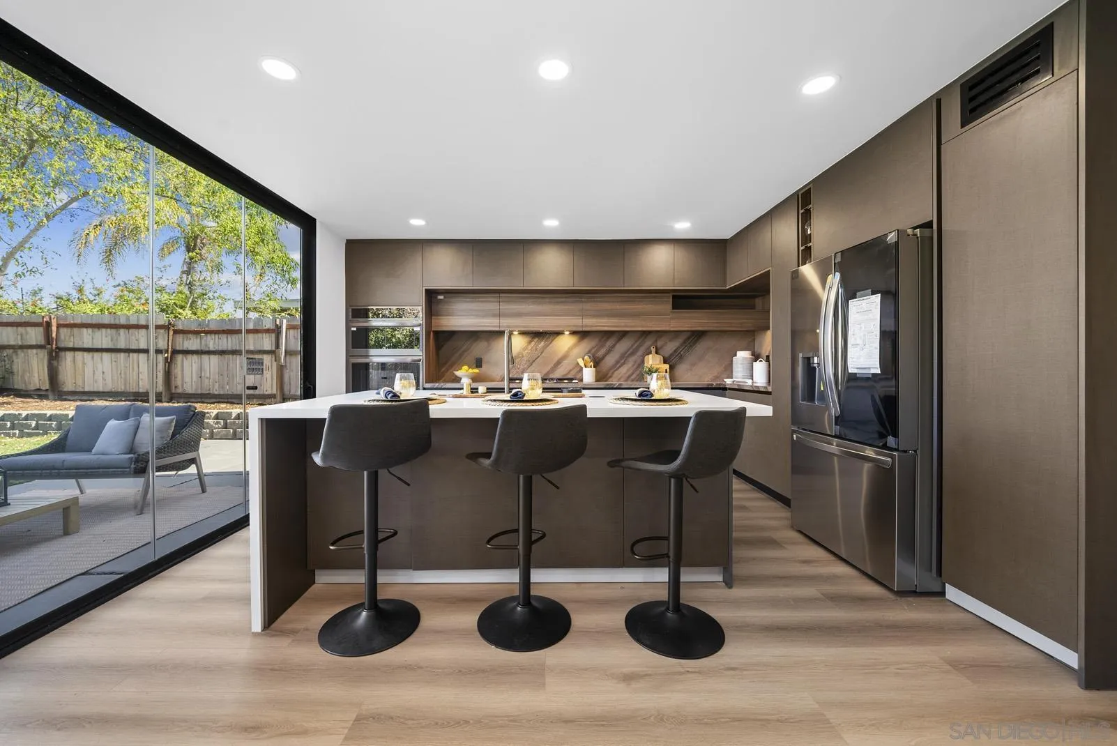 3523 Chauncey Road Oceanside, CA 92056 - Photo 12 of 34 a kitchen with stainless steel appliances kitchen island granite countertop a refrigerator a stove and white cabinets with wooden floor