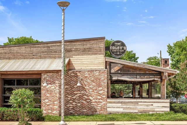 a view of a white house with a sink and porch next to a yard
