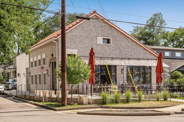 a view of a cafe with a table and chairs under an umbrella