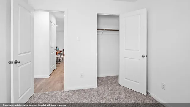 a view of a hallway with closet and a bathroom
