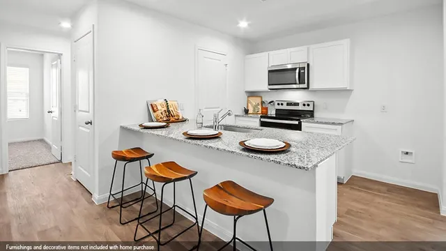 a kitchen with stainless steel appliances granite countertop a stove a sink a microwave and a refrigerator