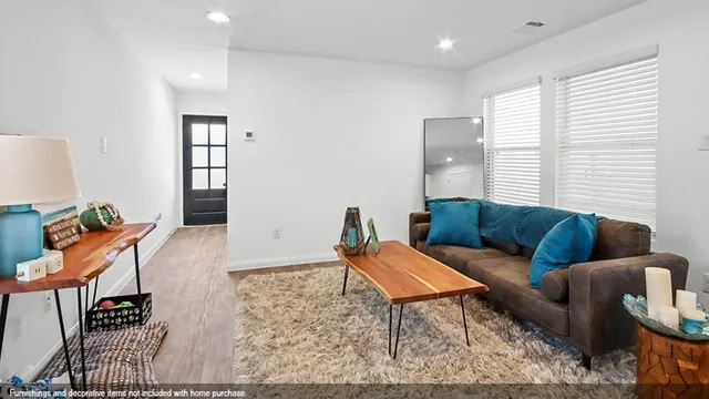 a living room with furniture a rug and a window