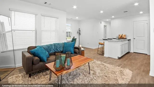 a living room with furniture and kitchen view