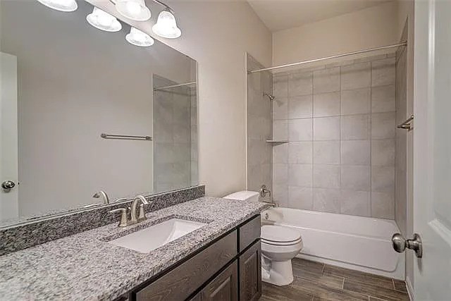 20008 Navarre Terrace Pflugerville, TX 78660 - Photo 15 of 18 a bathroom with a granite countertop sink toilet a mirror and shower
