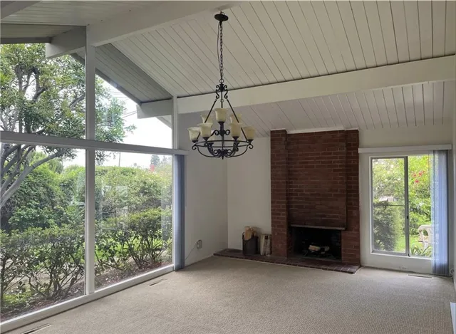 a view of empty room with fireplace and windows