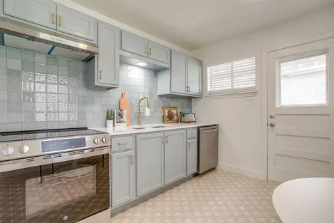 a kitchen with a sink stove and cabinets