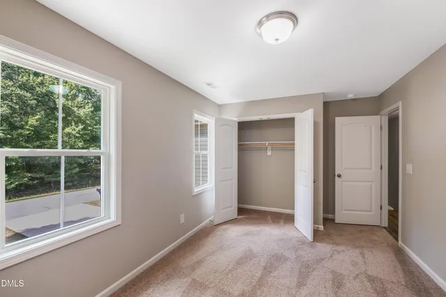 an empty room with windows and closet