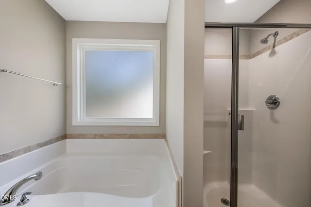 a white bath tub sitting next to a shower