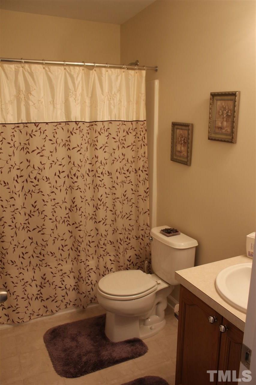 2150 Metacomet Way Raleigh, NC 27604 - Photo 14 of 24 a bathroom with a toilet and a shower curtain