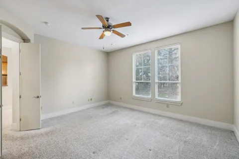 an empty room with a window and a ceiling fan