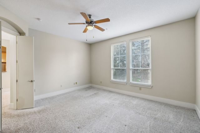 an empty room with a window and a ceiling fan