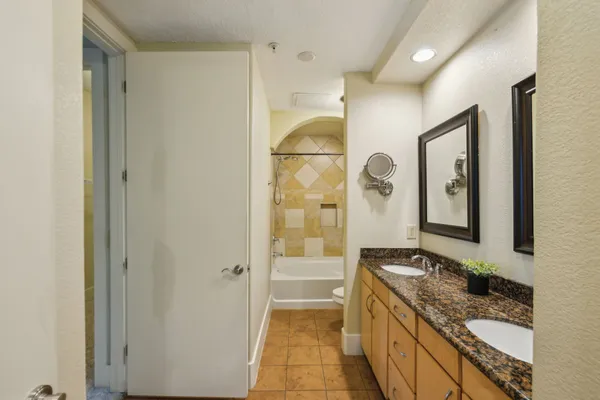 a bathroom with a granite countertop sink a mirror and a shower