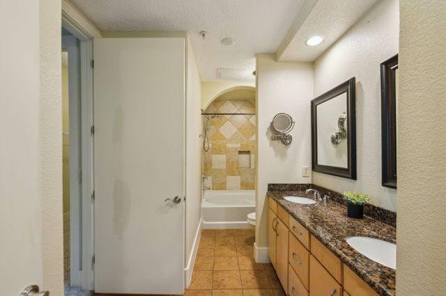 a bathroom with a granite countertop sink a mirror and a shower