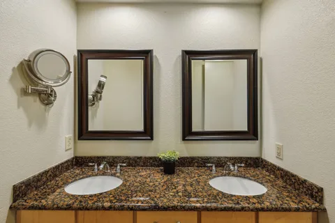 a bathroom with double vanity sinks and a mirror