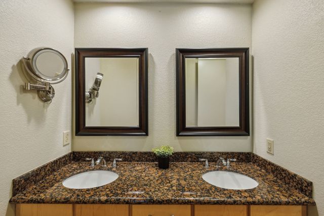 a bathroom with double vanity sinks and a mirror
