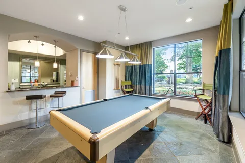 a room with pool table and windows