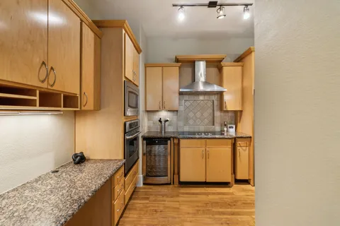 a kitchen with stainless steel appliances granite countertop a sink and a stove