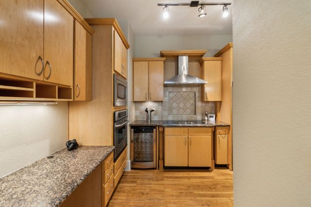 a kitchen with stainless steel appliances granite countertop a sink and a stove
