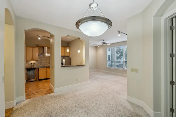 a view of a hallway with wooden floor and a kitchen