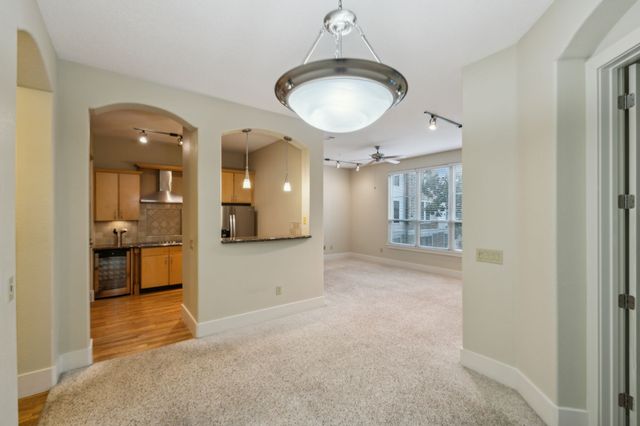 a view of a hallway with wooden floor and a kitchen