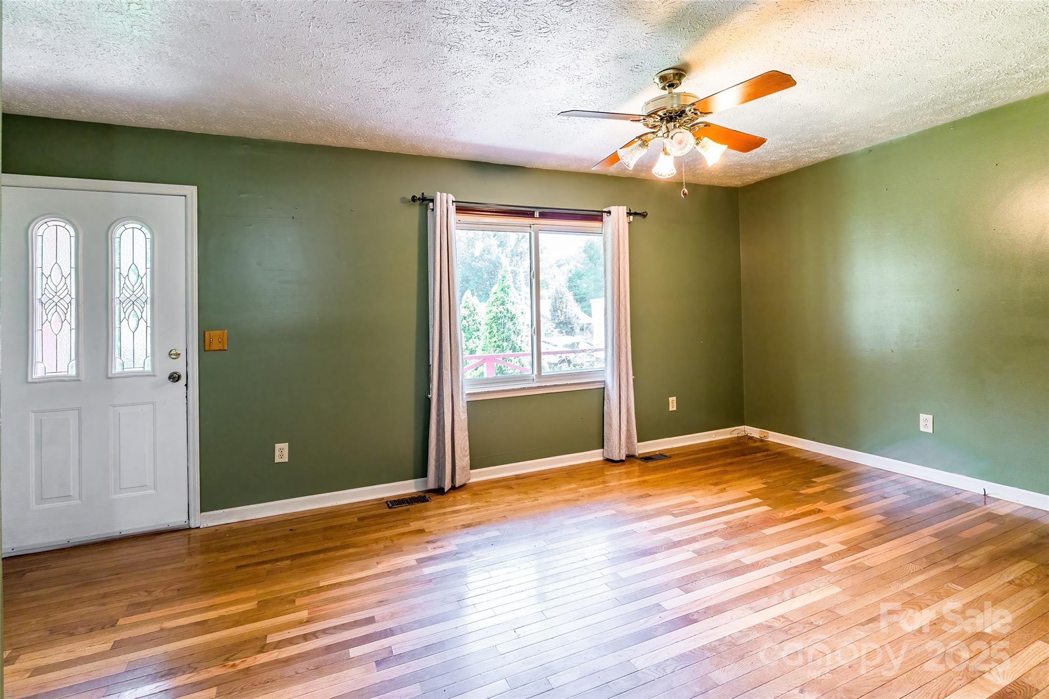 2675 Tablerock Road Lenoir, NC 28645 - Photo 4 of 31 a view of an empty room with wooden floor and a window