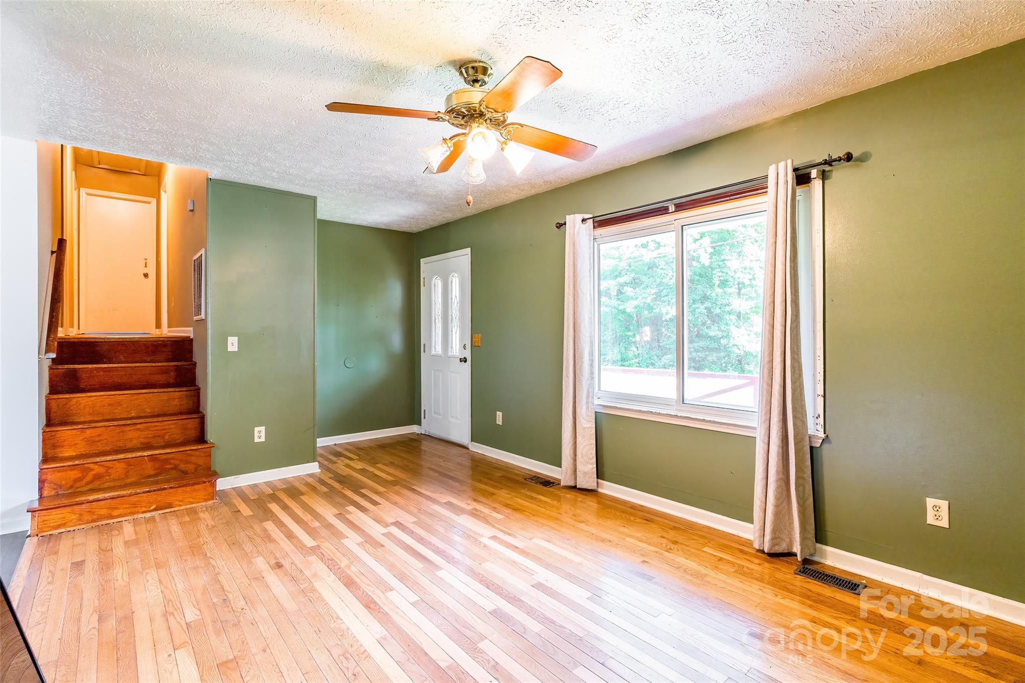 2675 Tablerock Road Lenoir, NC 28645 - Photo 5 of 31 a view of a room with wooden floor a ceiling fan and window