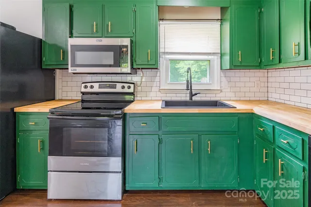 a kitchen with sink a microwave and cabinets