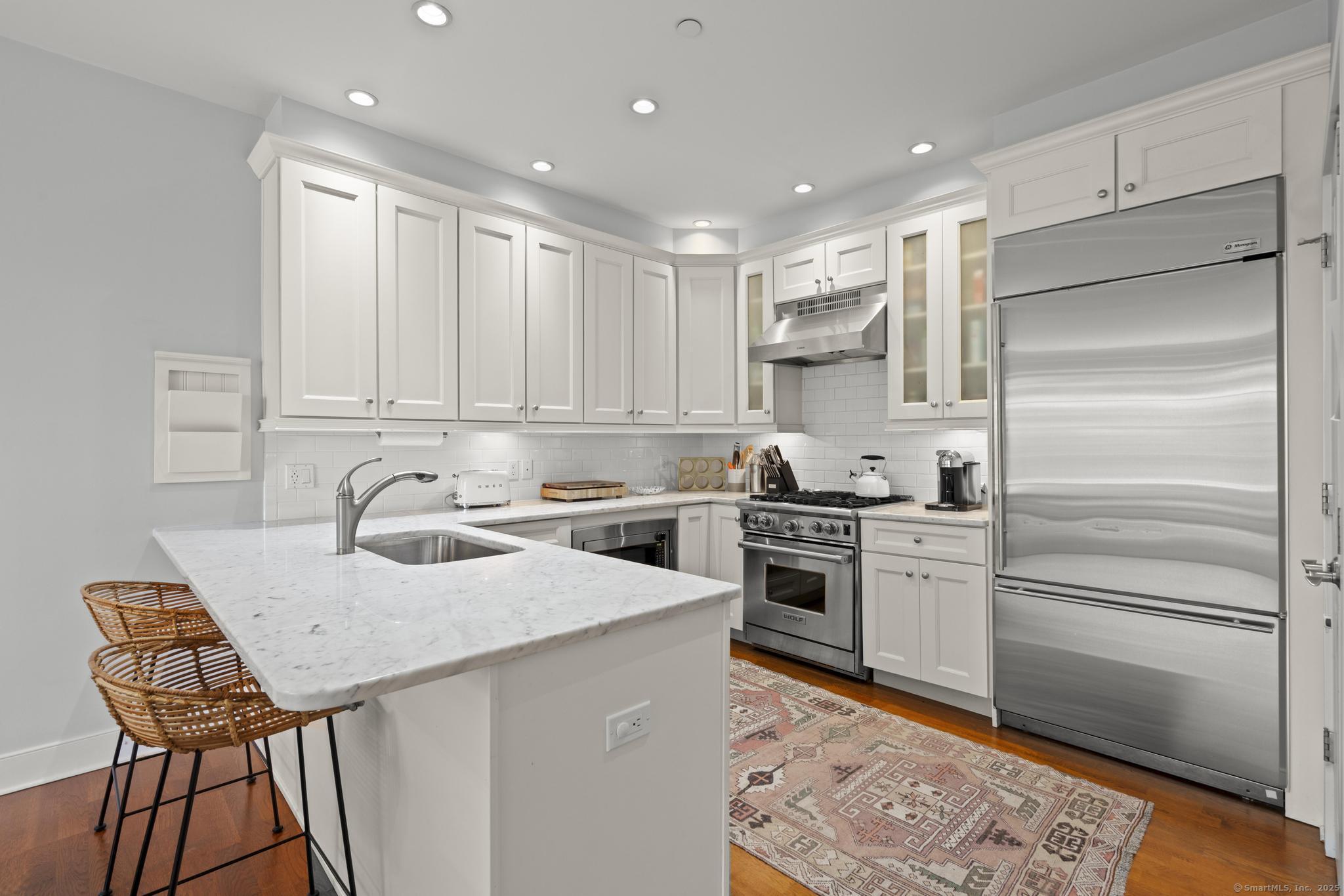 77 Havemeyer Lane, Unit 313 Stamford, CT 06902 - Photo 1 of 1 a kitchen with granite countertop stainless steel appliances and wooden cabinets